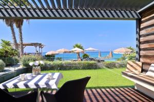 un patio con mesa, sillas y el océano en Hôtel Le Week end en Ajaccio
