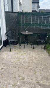 Duas cadeiras e uma mesa num pátio em Port Miller em Portstewart