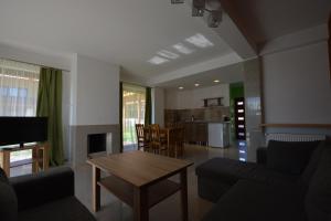 a living room with a couch and a table at Domyletnie Sarbinowo ogrodzony dom 92m2 in Sarbinowo