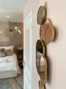 un miroir sur un mur à côté d'une chambre dans l'établissement Les Logis Aux portes de la Vallée de Chevreuse, 