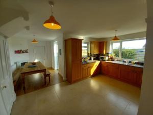a kitchen with wooden cabinets and a table in it at Beach House in Anglesey in Trearddur