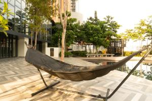 a hammock on a patio in front of a building at Lalaport Suites At Lucentia Bukit Bintang City Center in Kuala Lumpur