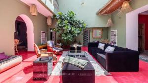 een woonkamer met een bank en een tafel bij Riad OLIVE Privatif 4 Personnes in Marrakesh