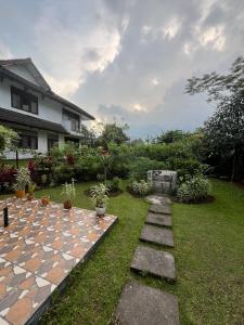 un jardin avec un chemin en pierre et une maison dans l'établissement Villa Bougenville 2, Jalan Raya Kota Bunga, à Puncak