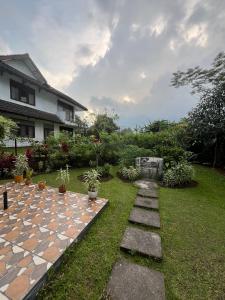 a garden with a stone path and a house at Villa Oma Bougenville 2 in Puncak