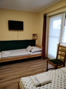a bedroom with two beds and a flat screen tv at Gulyás Vendégház in Tiszafüred