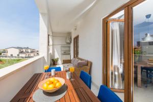 a wooden table with a bowl of fruit on a balcony at Apartment Blu in Poreč