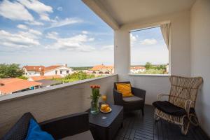 a balcony with a table and chairs and a large window at Apartment Blu in Poreč