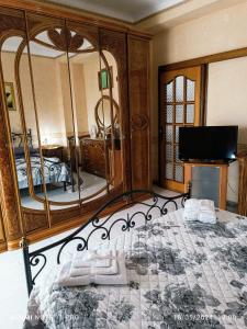een slaapkamer met een bed en een grote spiegel bij La casa Dei Mari in Taranto