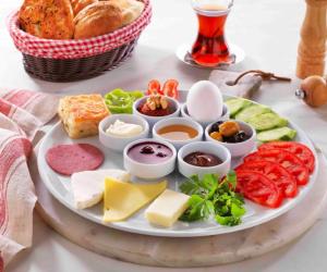 a plate of food with cheese and other foods on a table at Bodrum Liman Resort in Bodrum City