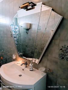 een badkamer met een wastafel en een spiegel bij La casa Dei Mari in Taranto