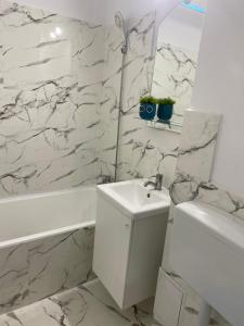 Un baño blanco con lavabo, bañera e inodoro. en Studio Garsoniera 552, en Bucarest 16 fotos más