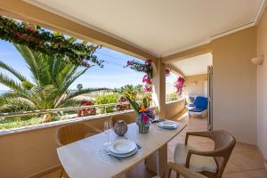 a dining room with a table and chairs and a large window at Vila Palmeira Beach Resort in Lagos