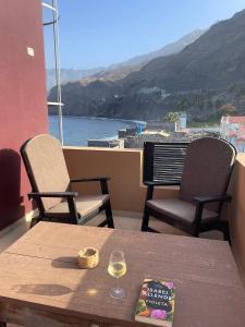 Paul的住宿－Tienne Del Mar，阳台上的桌椅和一杯葡萄酒