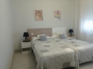 2 camas en una habitación blanca con 2 lámparas en Barrón 21 en Logroño