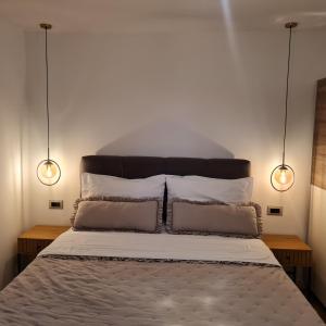 a bedroom with a bed with two lights above it at Apartment Mariniva in Kaštela