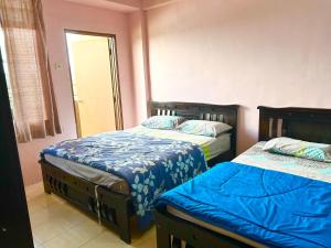 ブリンチャンにあるZurie Muslim Homestayのベッドルーム1室(ベッド2台付)、