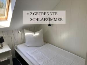 a small bed in a small room with a sign at Krabbe Apartment 10, zentral gelegen neben Muschel-und Krabbenmuseum, bis zu 2 Hunden kostenfrei willkommen in Wremen