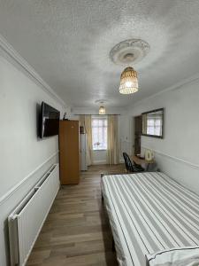 um quarto com uma cama e um lustre em Oxborne Rooms UK - 22 Seaton em Londres