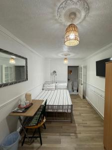 Un dormitorio con una cama y una mesa. en Oxborne Rooms UK - 22 Seaton en Londres