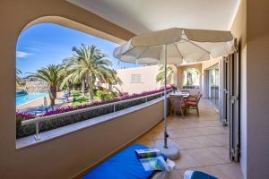 拉古什的住宿－圖里斯提克斯維拉帕爾梅拉公寓酒店，阳台配有桌子、遮阳伞和游泳池。