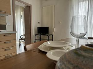 uma sala de jantar com uma mesa com pratos e um copo de vinho em Peschici a un passo em Peschici