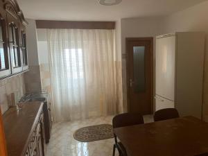 Una cocina con mesa y sillas y un refrigerador. en Callatis Suite, en Mangalia