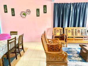 ブリンチャンにあるZurie Muslim Homestayのダイニングルーム(木製の椅子、テーブル付)