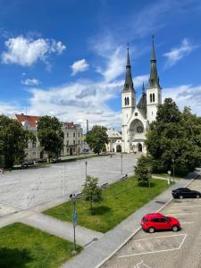 a red car parked in front of a church at Hostel Moravia Ostrava in Ostrava