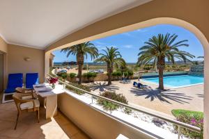 拉古什的住宿－圖里斯提克斯維拉帕爾梅拉公寓酒店，享有游泳池和棕榈树景致的阳台
