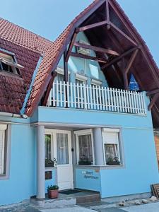 a house with a balcony on top of it at AMRI Apartman in Balatonföldvár