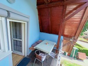 a table on the balcony of a house at AMRI Apartman in Balatonföldvár