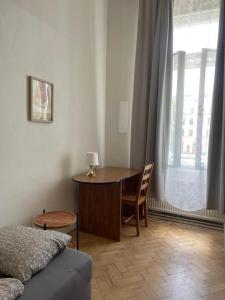 a room with a table and a bed and a window at Hostel Moravia Ostrava in Ostrava