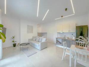 a white living room with a couch and a table at Oasis Acropolis Serres Next to Center in Serres