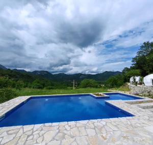 uma piscina com água azul e montanhas ao fundo em ZEN Relaxing Village 