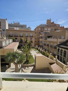 a view of a city with buildings and palm trees at Apartamentos Turísticos KENZAMIN in Alicante