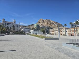 a street in a city with a mountain in the background at Apartamentos Turísticos KENZAMIN in Alicante +33 photos