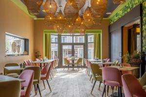 un restaurante con mesas, sillas y ventanas en Hotel De Boskar Pelt, en Overpelt