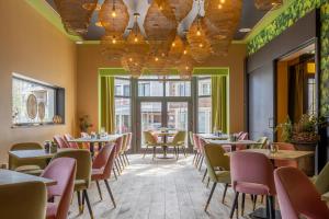 ein Restaurant mit Tischen und Stühlen und Fenstern in der Unterkunft Hotel De Boskar Pelt in Neerpelt