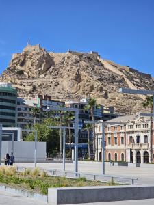 a city with a mountain in the background at Apartamentos Turísticos KENZAMIN in Alicante