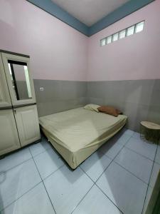 a small bedroom with a bed and a window at Pondok Syariah Hadikusuma in Rahayu