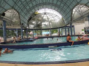 a group of people in a swimming pool at Suite na Morada do Sol in Piratuba