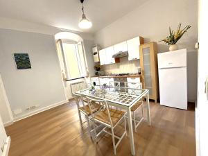 a kitchen with a table and a white refrigerator at CINQUE TERRE MONEGLIA in Moneglia