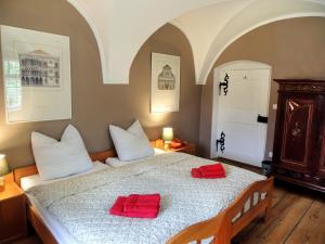 1 dormitorio con 1 cama con 2 almohadas rojas en Wohnung im Schlösschen, en Lichtenfels