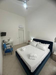 a bedroom with a bed with white sheets and a desk at Loredana Affittacamere in Vittoria