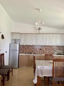 a kitchen with a table and a white refrigerator at Fabio Apartments Gjiri i Lalzit in Draç +23 photos
