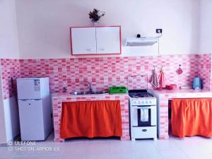 uma cozinha com paredes em tons de rosa e vermelho em aparthotelboavistacom em Sal Rei