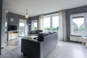 una sala de estar con un sofá y una mesa en KG- Vakantiewoning 20, en Opperdoes