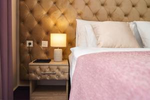 ein Schlafzimmer mit einem Bett und einer Lampe auf einem Nachttisch in der Unterkunft Hotel Stella Maris - Style & Comfort in Vodice + 37 Fotos