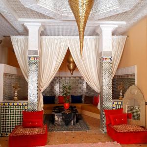 a living room with a couch and red pillows at Golf Stinia hôtel & Spa in Meknès